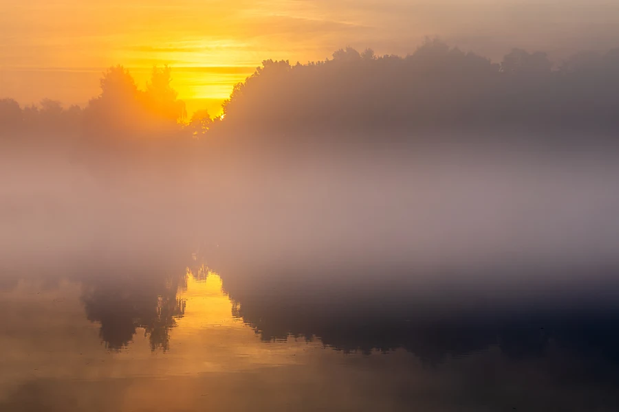 Mgła nad wodą w świetle wschodzącego słońca